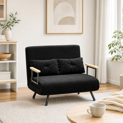 Layered blankets and cushions on a sofa creating a warm, inviting autumn living room setting